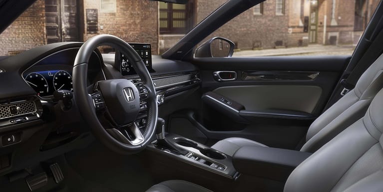 2026 Honda Civic Hatchback Touring Hybrid front cabin with leather-trimmed seats and dashboard (Compact Hatchback).