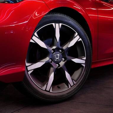 2027 Honda Civic Sedan Sport Touring Hybrid in Rallye Red close-up of the front wheel and side profile (Compact Sedan)
